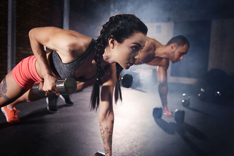 confident-couple-working-out-with-dumbbell